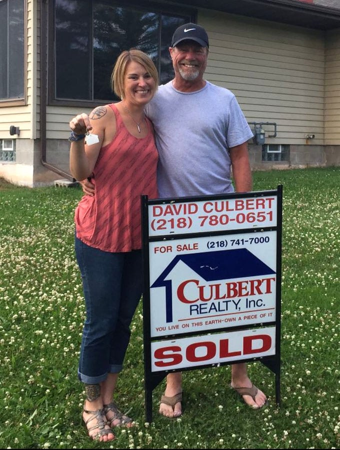 Couple in front of their new home holding their new house keys
